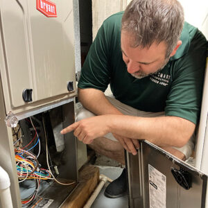 Owner Morgan Pellitteri inspecting a furnace in a residential basement.